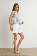 Load image into Gallery viewer, Woman wearing a light blue sleeveless top and white shorts against a plain background