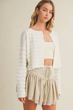 Load image into Gallery viewer, Woman wearing a white cardigan over a beige top and patterned skirt on a plain background
