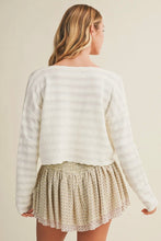 Load image into Gallery viewer, Woman wearing a white textured sweater and patterned skirt on a beige background