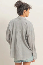 Load image into Gallery viewer, Person wearing a gray striped shirt with a plain background