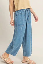 Load image into Gallery viewer, Person wearing light blue denim pants on a beige background