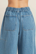 Load image into Gallery viewer, Close-up of blue denim pants with a neutral background
