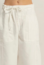 Load image into Gallery viewer, White pants with a tie waist on a plain background