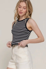 Load image into Gallery viewer, Woman wearing a black and white striped tank top and white pants against a plain background