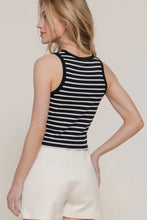 Load image into Gallery viewer, Woman wearing a black and white striped tank top and white shorts on a plain background