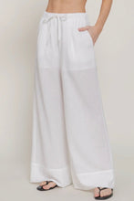 Load image into Gallery viewer, White wide-leg pants worn by a person on a plain background