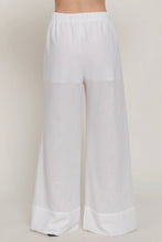 Load image into Gallery viewer, White wide-leg pants on a plain background