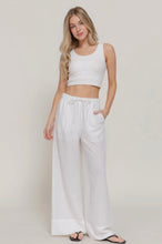 Load image into Gallery viewer, Woman wearing a white sleeveless top and wide-leg pants on a plain background