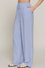 Load image into Gallery viewer, Blue and white striped pants worn by a person on a plain background