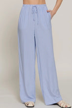 Load image into Gallery viewer, Blue and white striped pants worn by a person on a plain background