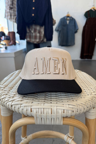 Wicker chair with 'ALMEN' branding in a clothing store setting