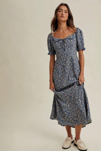 Load image into Gallery viewer, Woman wearing a blue floral dress on a plain background
