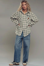 Load image into Gallery viewer, Person wearing a green plaid shirt and blue jeans on a gray background