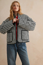 Load image into Gallery viewer, Person wearing a black and white checkered jacket with a plain background