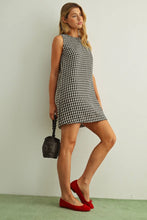 Load image into Gallery viewer, Woman wearing a black and white checkered dress with red shoes against a plain background