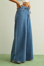 Load image into Gallery viewer, Person wearing wide-leg blue jeans on a plain background