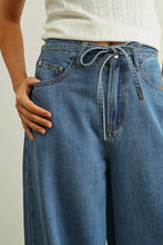 Load image into Gallery viewer, Person wearing blue jeans with a white background