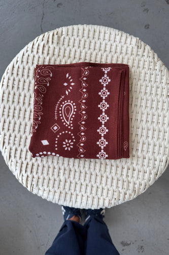 Brown bandana with white patterns on a woven surface