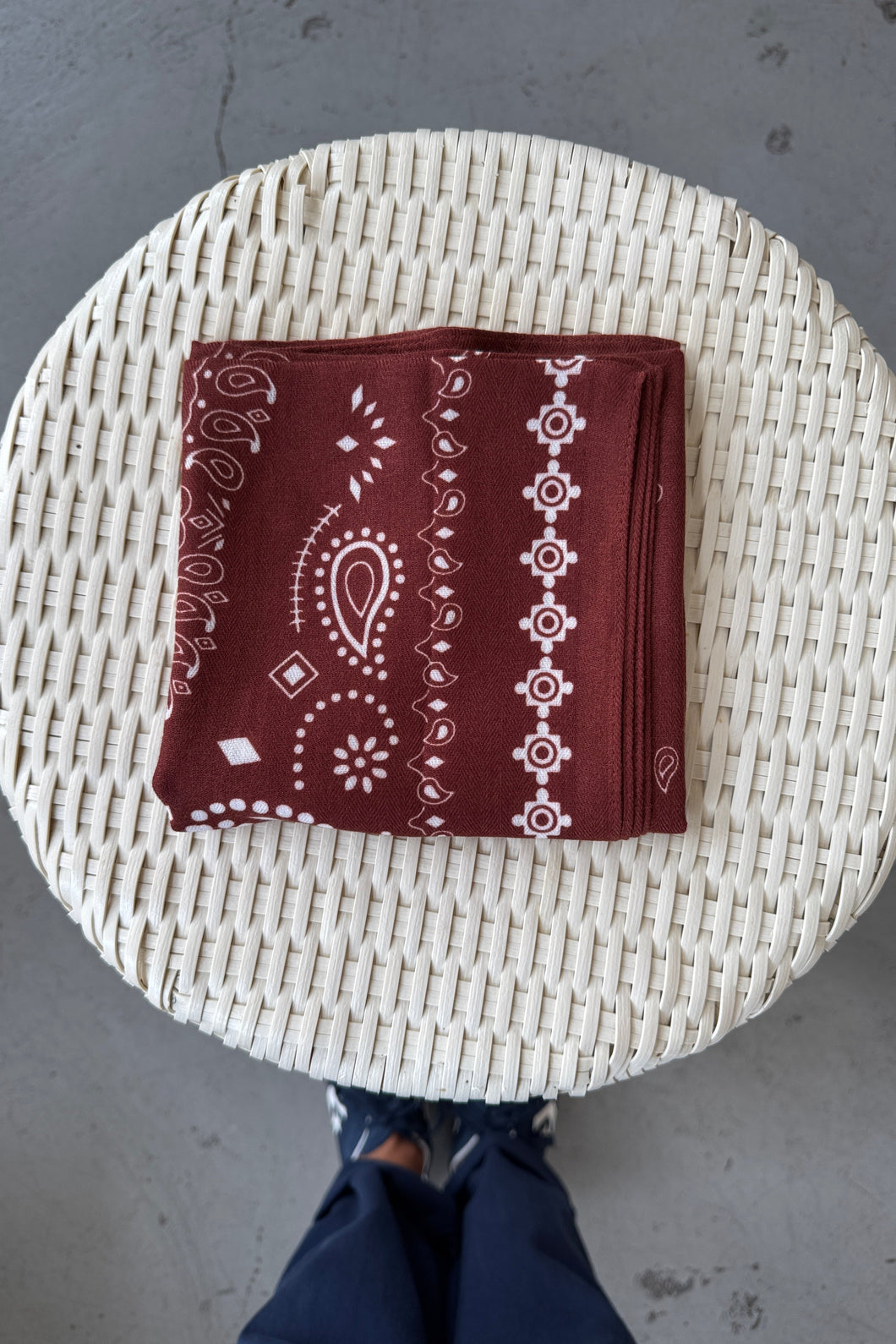 Brown bandana with white patterns on a woven surface
