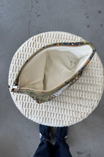 Load image into Gallery viewer, Round woven basket with floral-patterned lining on a gray surface