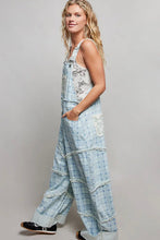 Load image into Gallery viewer, Woman wearing a floral overalls on a plain background