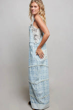 Load image into Gallery viewer, Woman wearing a long, light blue denim dress with floral patterns on a plain background