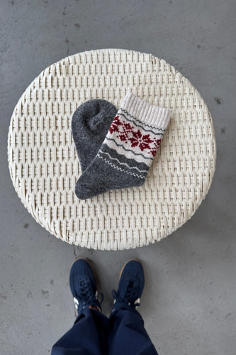 Round woven mat with socks on a concrete floor