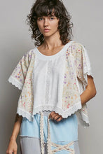 Load image into Gallery viewer, Woman wearing a floral kimono-style top over a white shirt with light blue pants on a gray background