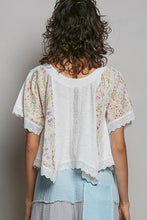 Load image into Gallery viewer, Woman wearing a white blouse with floral sleeves against a plain background