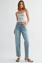 Load image into Gallery viewer, Woman wearing a white crop top and blue jeans on a white background