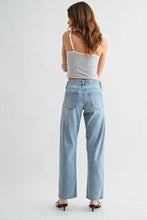 Load image into Gallery viewer, Woman wearing light blue jeans and a white top on a plain background