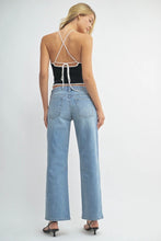 Load image into Gallery viewer, Woman wearing a black strappy top and light blue jeans on a white background