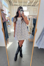 Load image into Gallery viewer, Person wearing a floral dress and black boots in a clothing store.