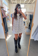 Load image into Gallery viewer, Person wearing a floral dress and black boots in a clothing store.