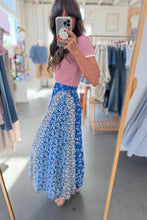 Load image into Gallery viewer, Woman taking a mirror selfie wearing a pink top and blue floral skirt in a clothing store.