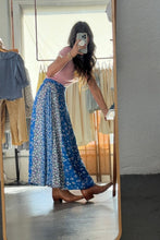Load image into Gallery viewer, Person wearing a blue floral skirt in a clothing store.