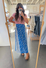 Load image into Gallery viewer, Woman taking a mirror selfie wearing a blue floral skirt and pink top in a clothing store.