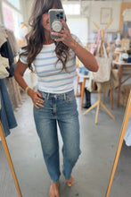 Load image into Gallery viewer, Person taking a mirror selfie wearing a striped top and jeans in a clothing store.