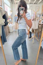 Load image into Gallery viewer, Woman taking a mirror selfie wearing a striped shirt and jeans in a clothing store.