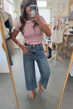 Load image into Gallery viewer, Person taking a mirror selfie wearing a striped shirt and wide-leg jeans in a store.