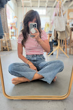 Load image into Gallery viewer, Person taking a mirror selfie wearing a striped shirt and jeans in a clothing store.