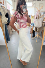 Load image into Gallery viewer, Person taking a mirror selfie wearing a red and white striped shirt and white pants in a clothing store.