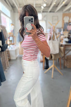 Load image into Gallery viewer, Woman taking a mirror selfie wearing a red and white striped shirt and white pants in a store.