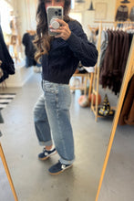 Load image into Gallery viewer, Person taking a mirror selfie wearing a dark sweater and light blue jeans in a clothing store.