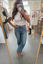 Load image into Gallery viewer, Person taking a mirror selfie wearing a striped top and jeans in a clothing store.