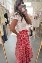 Load image into Gallery viewer, Woman taking a mirror selfie wearing a white top and red floral skirt in a clothing store.