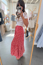 Load image into Gallery viewer, Woman taking a mirror selfie wearing a red floral skirt in a clothing store.