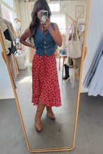Load image into Gallery viewer, Woman taking a mirror selfie wearing a blue top and red floral skirt in a store.