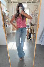 Load image into Gallery viewer, Person taking a mirror selfie wearing a red checkered top and blue jeans in a store.