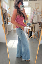 Load image into Gallery viewer, Woman taking a mirror selfie wearing a red checkered top and blue jeans in a store.